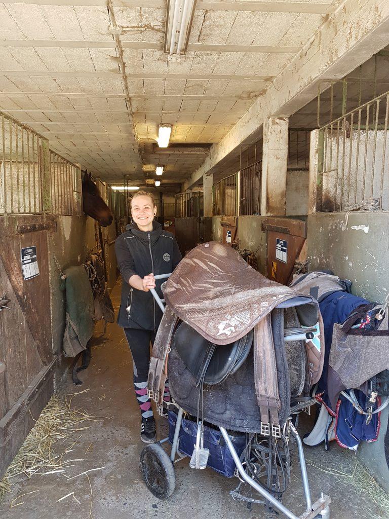 La jeune Léa qui prépare les selles dans une écurie