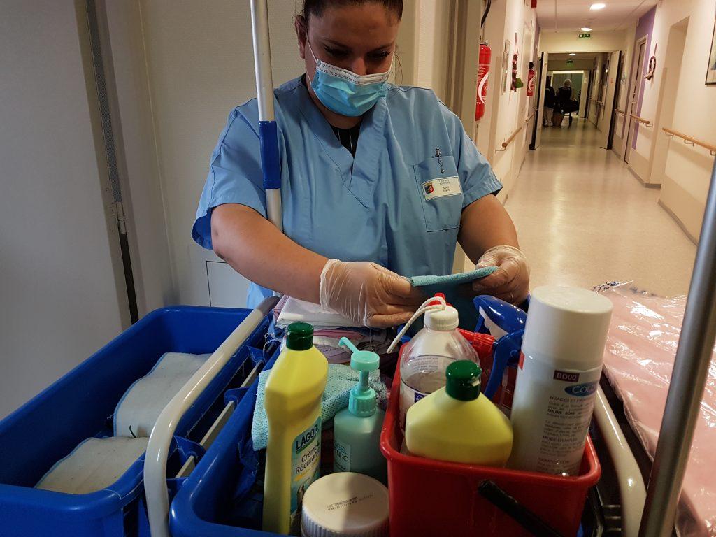 La jeune Estérina qui prépare les produits d'entretien sur son chariot de nettoyage