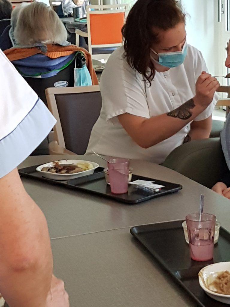 La jeune pauline qui aide une personne âgée à prendre son repas