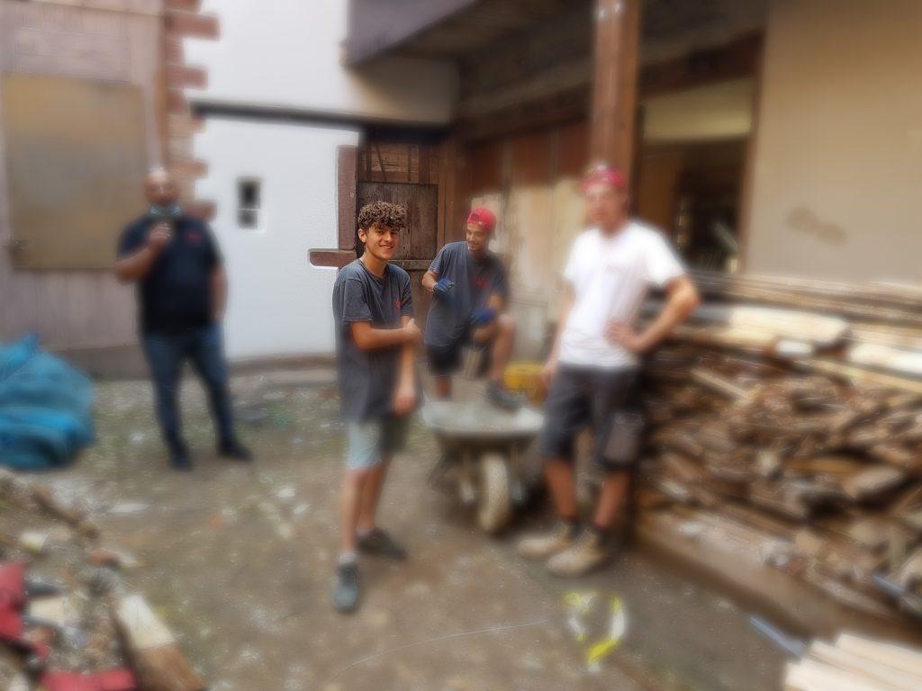 Le jeune Yoan qui scie du bois avec ses collègues